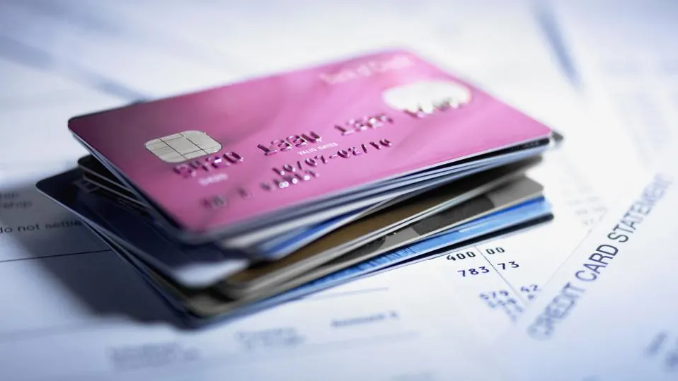 Stack of credit cards on top of paper credit card statements